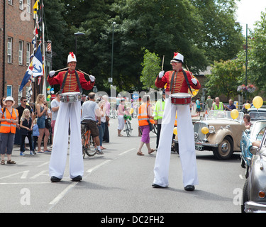 Hampton Wick Festival 2013 - Stelzenläufer signalisieren den Beginn der Prozession Stockfoto