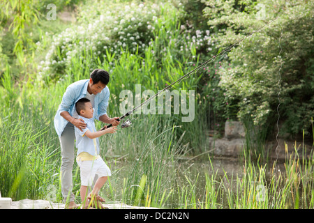 Happy Chinese Vater und Sohn Angeln in einem park Stockfoto