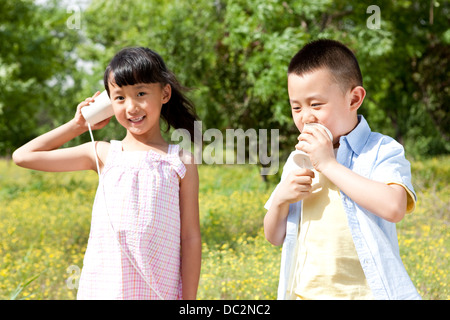 Glücklich chinesische Kinder spielen Spielzeug Telefon in einem park Stockfoto