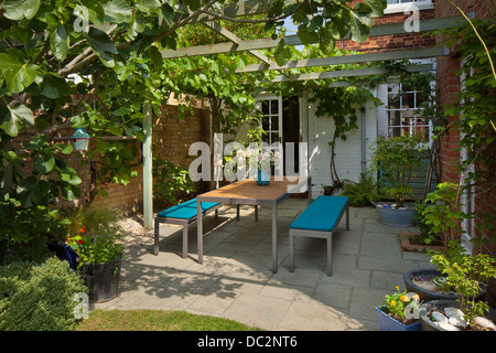 Moderne Gartenmöbel unter Pergola aus Holz und schattigen Patio im englischen Garten, England Stockfoto