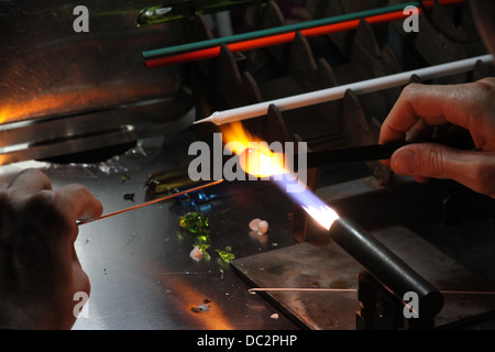 Glaser mit Gas Fackel leuchtet beim Mischen und gestalten eine Stück Glas 4 Stockfoto