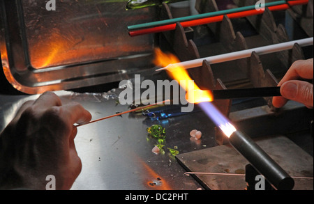 Glaser mit Gas Fackel leuchtet beim Mischen und gestalten eine Stück Glas 5 Stockfoto