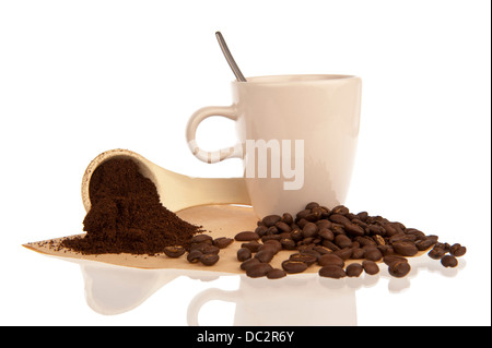 Kaffeetasse mit Bohnen und Pulver Löffel verzierten auf einen Kaffeefilter Stockfoto