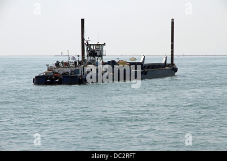 großes Boot für den Transport von Baumaterial auf die Baustelle eines Staudamms Stockfoto