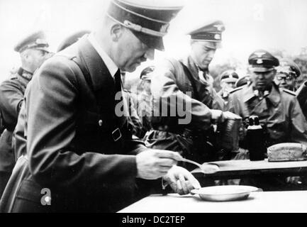 Die Nazi-Propaganda! Das Bild zeigt Adolf Hitler während eines Besuchs an der Front, der im April 1941 ein Soldatengericht aß. Fotoarchiv für Zeitgeschichte Stockfoto