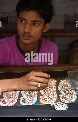 Mann Stiching Perlen Sari in Varanasi in Indien Stockfoto