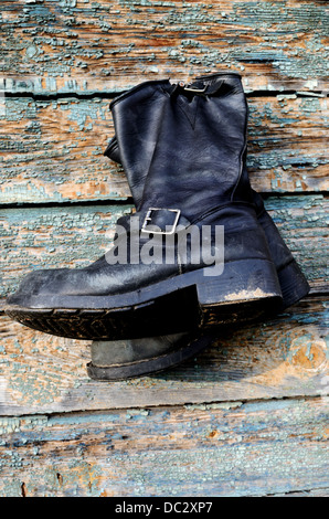 alte Vintage Leder Stiefel hängen die Holzwand Stockfoto