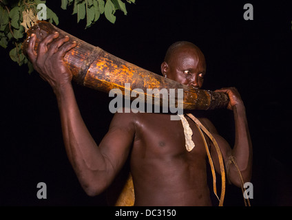 Bodi-Stamm Mann bläst In ein Elephant Tusk bei Kael Zeremonie, Hana Mursi, Omo-Tal, Äthiopien Stockfoto