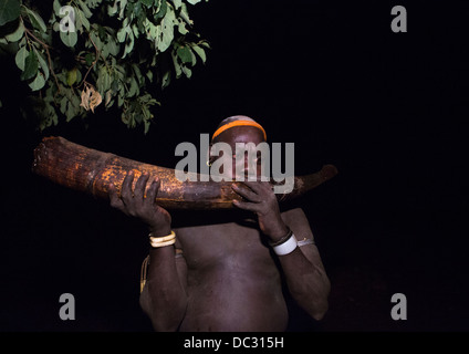 Bodi-Stamm Mann bläst In ein Elephant Tusk bei Kael Zeremonie, Hana Mursi, Omo-Tal, Äthiopien Stockfoto