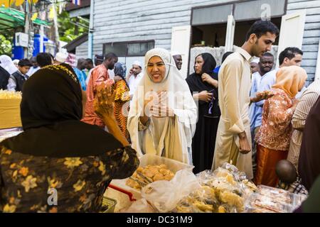 Bangkok, Thailand. 8. August 2013. Eine Frau kauft Lebensmittel auf einem freien Markt neben Haroon Moschee nach Eid al-Fitr-Services. Eid al-Fitr ist '' Festival brechen des Fastens,'' es nennt auch die geringeren Eid. Es ist ein wichtiger religiöser Feiertag von Moslems weltweit gefeiert, der markiert das Ende des Ramadan, der islamische heilige Monat des Fastens. Die religiösen Eid ist ein Tag und Muslime sind nicht gestattet, an diesem Tag zu fasten. Bildnachweis: ZUMA Press, Inc./Alamy Live-Nachrichten Stockfoto