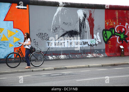 "Wir wollen die Mauer zurück", steht auf einem Gemälde von der East Side Gallery in Berlin am 13. Juli 2013. Foto: Wolfram Steinberg dpa Stockfoto