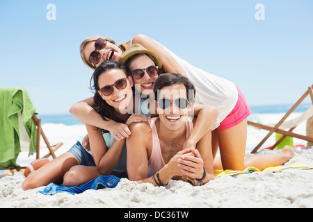 Porträt der happy Friends Verlegung übereinander am Strand Stockfoto