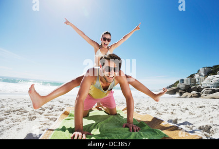 Begeisterten paar Huckepack auf Strand Stockfoto