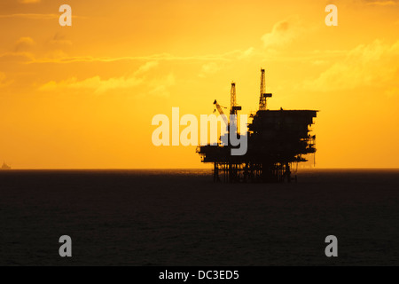 Silhouette von einer Offshore-Bohrinsel fern am Horizont zu Sonnenaufgang/Sonnenuntergang Zeit. Stockfoto