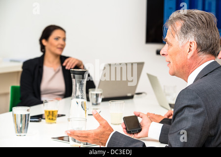 Gemischte Gruppe im Business-Meeting mit Laptops, Projektions-Leinwand, digitale Tablets und Smartphones diskutieren die neuesten Vertrieb fig Stockfoto