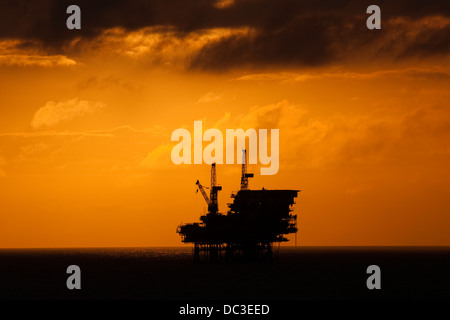 Silhouette von einer Offshore-Bohrinsel fern am Horizont zu Sonnenaufgang/Sonnenuntergang Zeit. Stockfoto