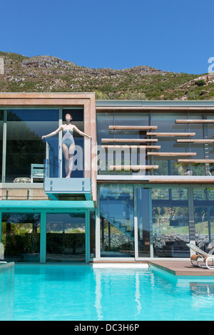 Frau auf dem Balkon über dem Schwimmbad Stockfoto