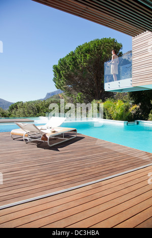 Frau auf dem Balkon über dem Schwimmbad Stockfoto