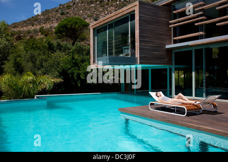 Frau im Liegestuhl am Pool Sonnenbaden Stockfoto