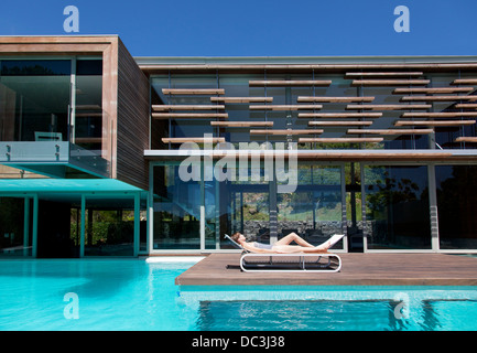 Frau im Liegestuhl am Pool Sonnenbaden Stockfoto