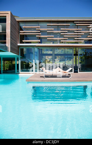 Frau im Liegestuhl am Pool Sonnenbaden Stockfoto