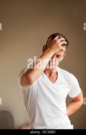 Mann hält zurück und Kopf Schmerzen Stockfoto