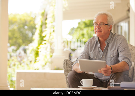 Lächelnder Mann mit digital-Tablette auf Veranda Stockfoto