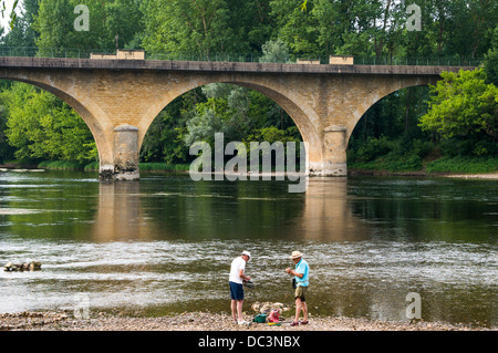 Zwei alte Männer angeln in flachen Gewässern in der Nähe der Brücke in Limeuil, liegt dort, wo die Flüsse Dordogne und Vézère, South West France. Stockfoto