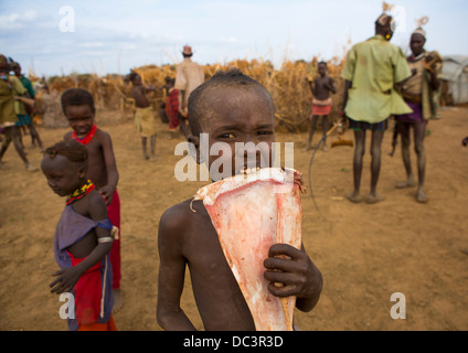 Dassanech Stamm Krieger Kuh Fleisch während einer Zeremonie, Omorate, Omo-Tal, Äthiopien Stockfoto