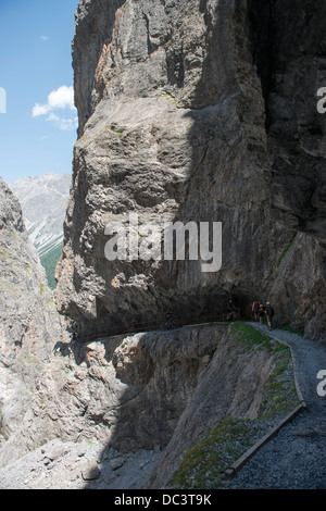 Wanderer Und Mountain-Biker Auf Felsenweg in der Uinaschlucht - Wanderer und Mountainbiker auf dem steilen Wanderweg, Val d Uina Stockfoto