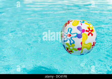 Bunte Beach-Ball schwimmt auf Wasser des Swimmingpools Stockfoto