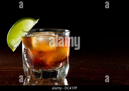 Cuba Libre, Rum und Cola cocktail serviert in einem kurzen Glas mit einer Kalk-Garnitur Stockfoto