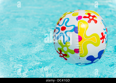 Bunte Beach-Ball schwimmt auf Wasser des Swimmingpools Stockfoto