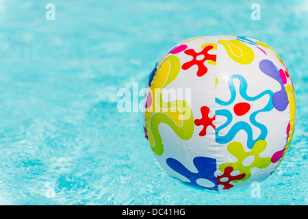Bunte Beach-Ball schwimmt auf Wasser des Swimmingpools Stockfoto