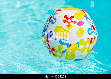 Bunte Beach-Ball schwimmt auf Wasser des Swimmingpools Stockfoto