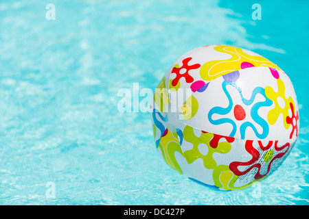 Bunte Beach-Ball schwimmt auf Wasser des Swimmingpools Stockfoto