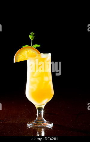 Schraubendreher, frischen Orangensaft mit Wodka serviert in einem Stamm Glas auf einem dunklen Balken Stockfoto