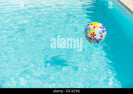 Bunte Beach-Ball schwimmt auf Wasser des Swimmingpools Stockfoto