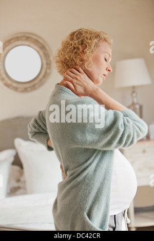 Schwangere Frau Holding Nacken und Rücken Schmerzen Stockfoto