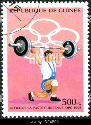 GUINEA - ca. 1995: Eine Briefmarke gedruckt in Guinea, gewidmet Olympischen Sommerspiele in Atlanta, zeigt Gewichtheber, ca. 1995 Stockfoto