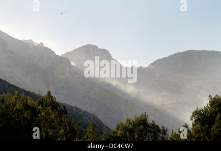 Rauch fliegt über Estellencs Bergen auf der Insel Mallorca, nachdem ein massives Feuer rund 2300 Hektar ausgebreitet. Stockfoto