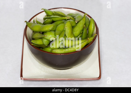 Authentische japanische Küche mit einem zeitgenössischen amerikanischen Flair fotografiert. Eine Schüssel mit gekochten Edamame Hülsen. Stockfoto