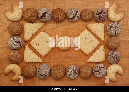 Haselnuss, Schokolade und Ingwer Cookies Frame auf Holzbrett mit Stapeln Cookie ornament Stockfoto