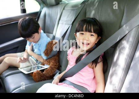 Schöne Mädchen und der Junge sitzt auf dem Auto Rücksitz Stockfoto