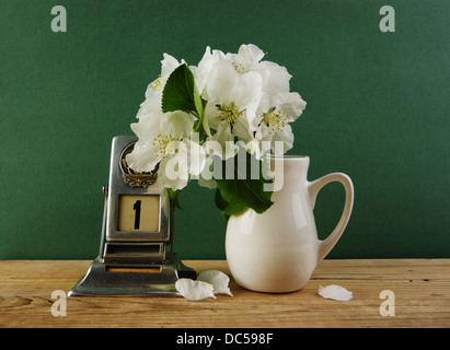 Alter Kalender und Vogel-Kirsche Zweig in einen Krug auf dem Holztisch Stockfoto