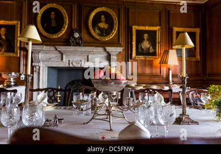 Somerset, England. 8. August 2013. Eine georgische Speisesaal Tischdekoration mit Porträts aus dem 18. Jahrhundert und einem Kamin aus Marmor. Stockfoto