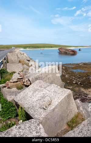 Der Beton blockiert, die Teil des Churchill Barrier 3 mit den Resten einer Blockship zwischen Blick Holm und Burray, Orkney. Stockfoto