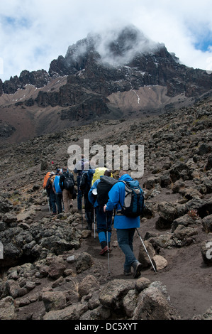 Eine Gruppe von Trekker, die ihren Weg durch die Lavafelder, am Mawenzi Tarn camp auf der Rongai route Stockfoto