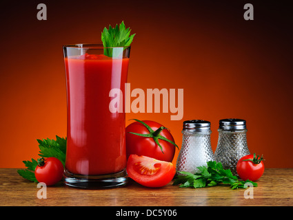 Stillleben mit Glas frischer Tomatensaft, Tomaten, Petersilie, Salz und Pfeffer Stockfoto