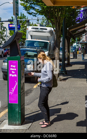 Junge Frauen zahlen für PKW-Parkplatz in der Innenstadt von Olympia, Washington, USA Stockfoto